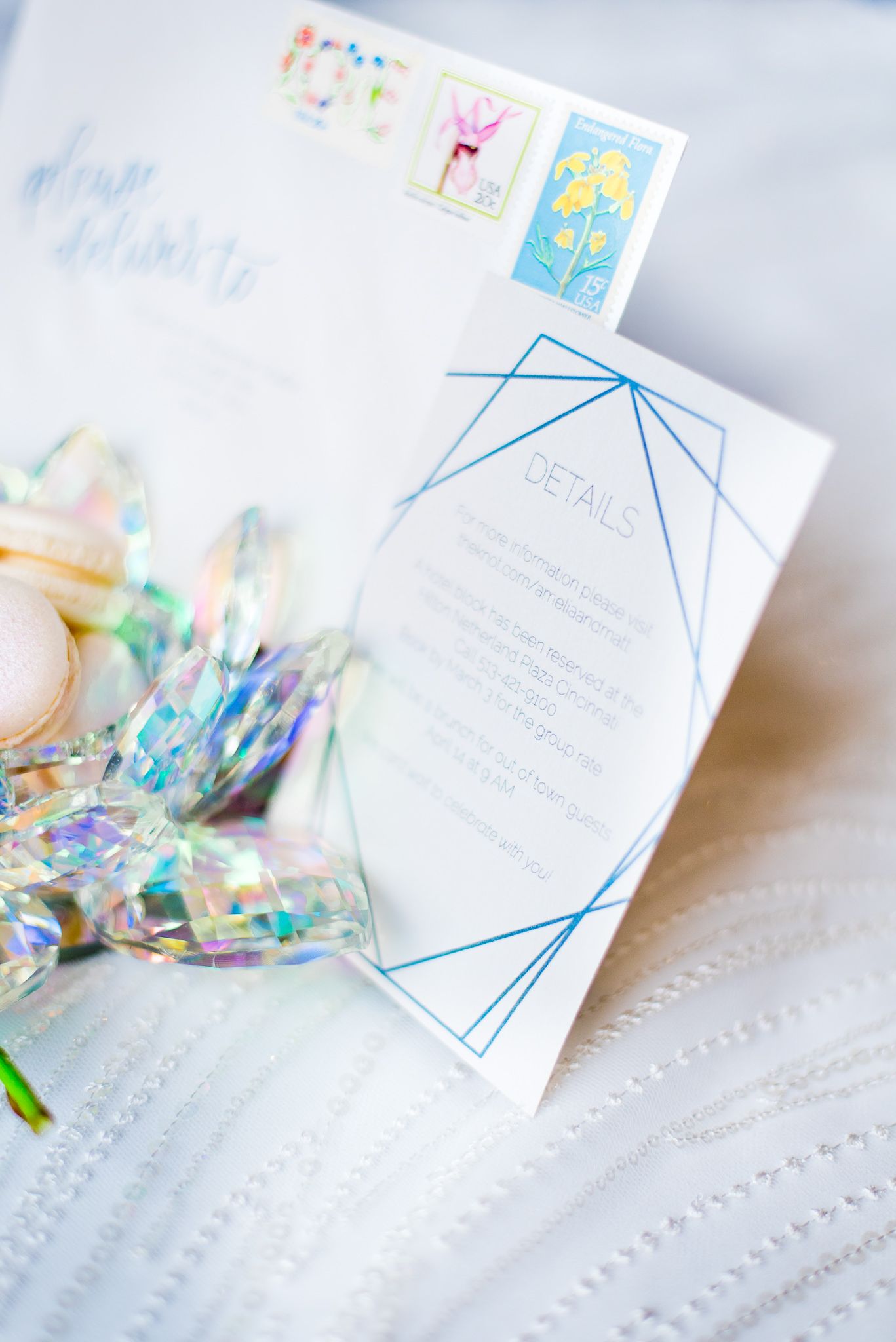 close up of blue and white wedding invitation next to a rainbow crystal bowl for a wedding at The Center Cincinnati