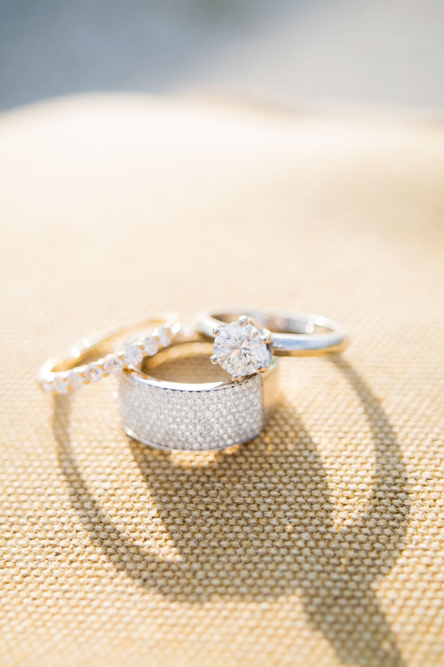 three wedding bands and engagement ring stacked together