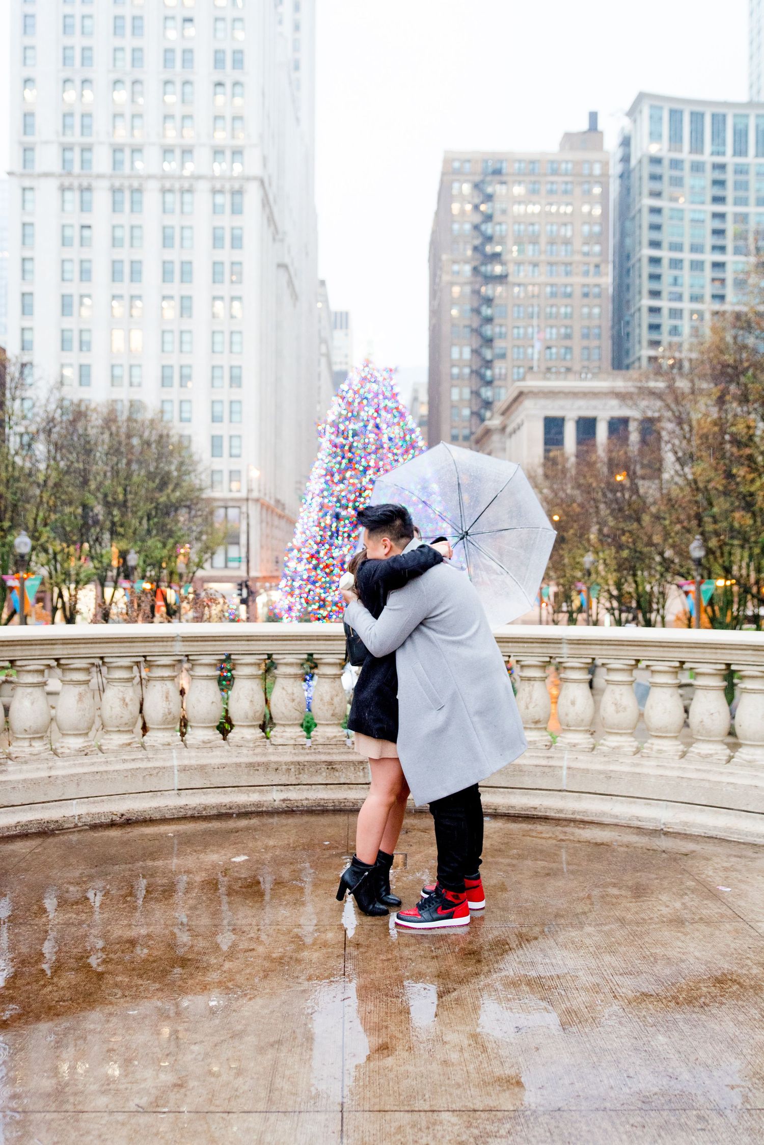 young couple hugging in front of Millennium Park Christmas Tree after Chicago Proposal