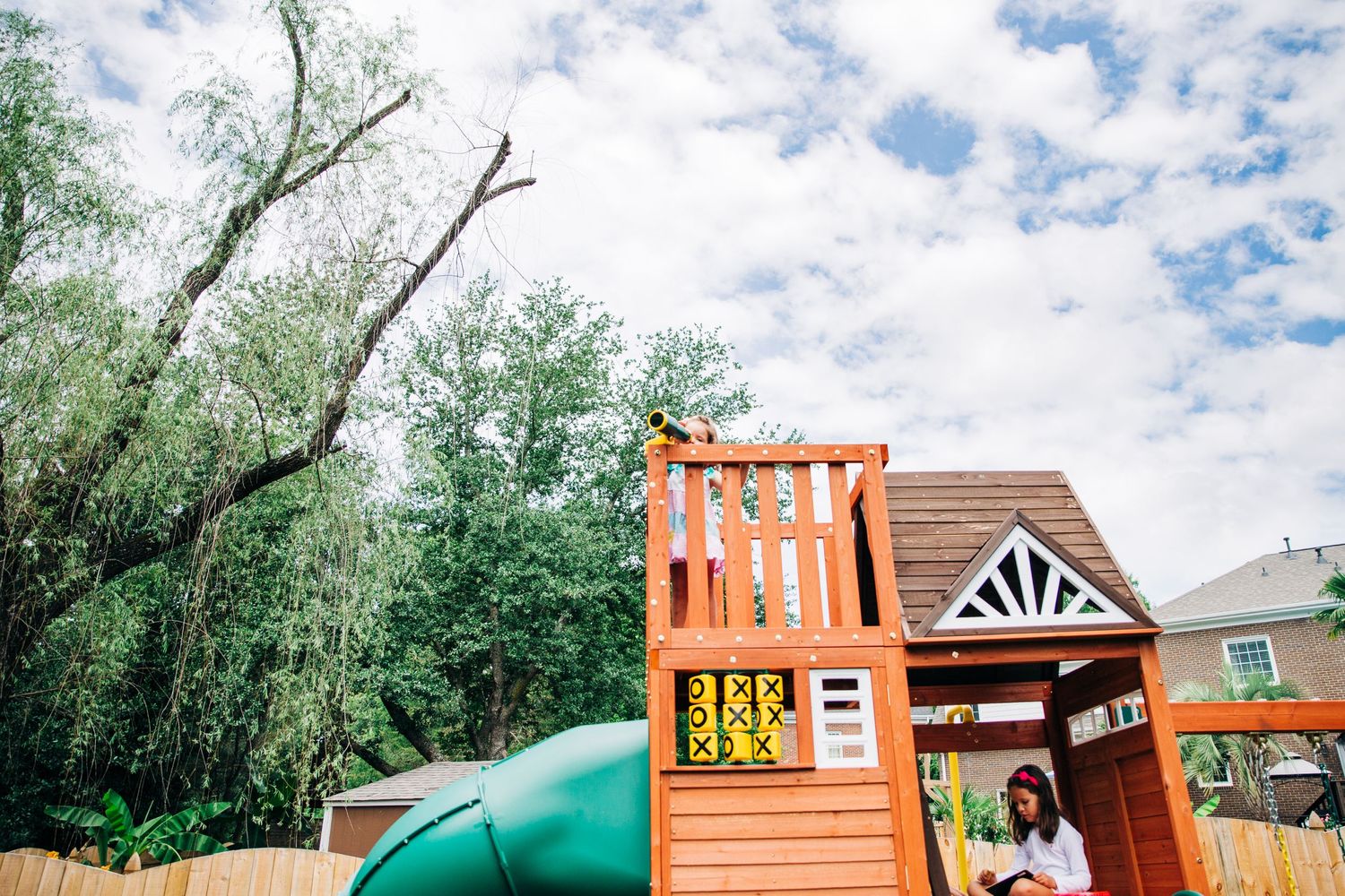 sisters playing on swing set in backyard