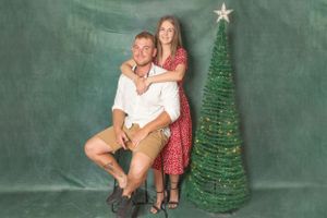 couple embrace next to Christmas tree