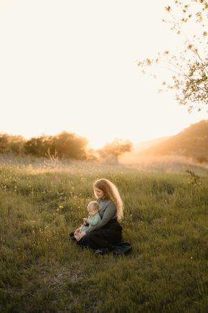 Motherhood photoshoot by Tiffany Kelterer, photographer in San Diego of mom sitting in flowers at Mission Trails