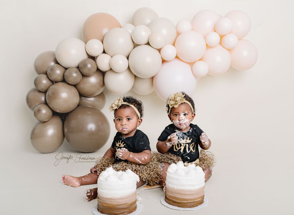 Twins enjoy their first taste of birthday cake during their first birthday session in Colorado Springs.