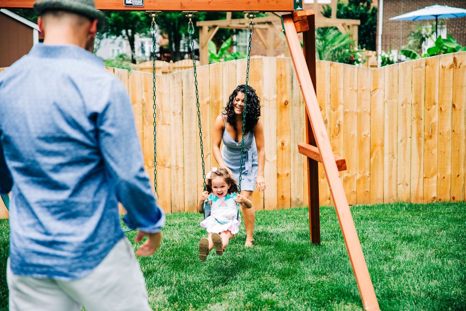 Parents pushing daughter on swings during Charlotte, NC family photo session