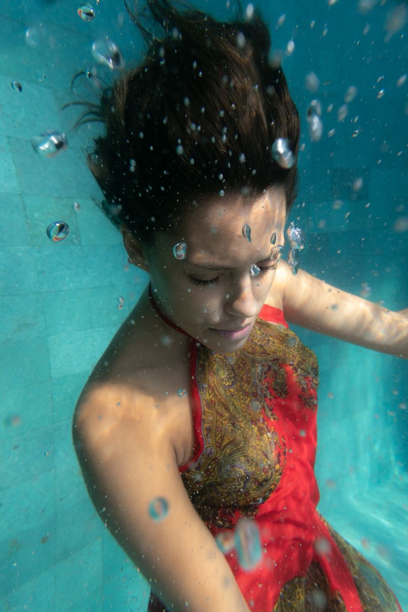 A woman in a red dress underwater