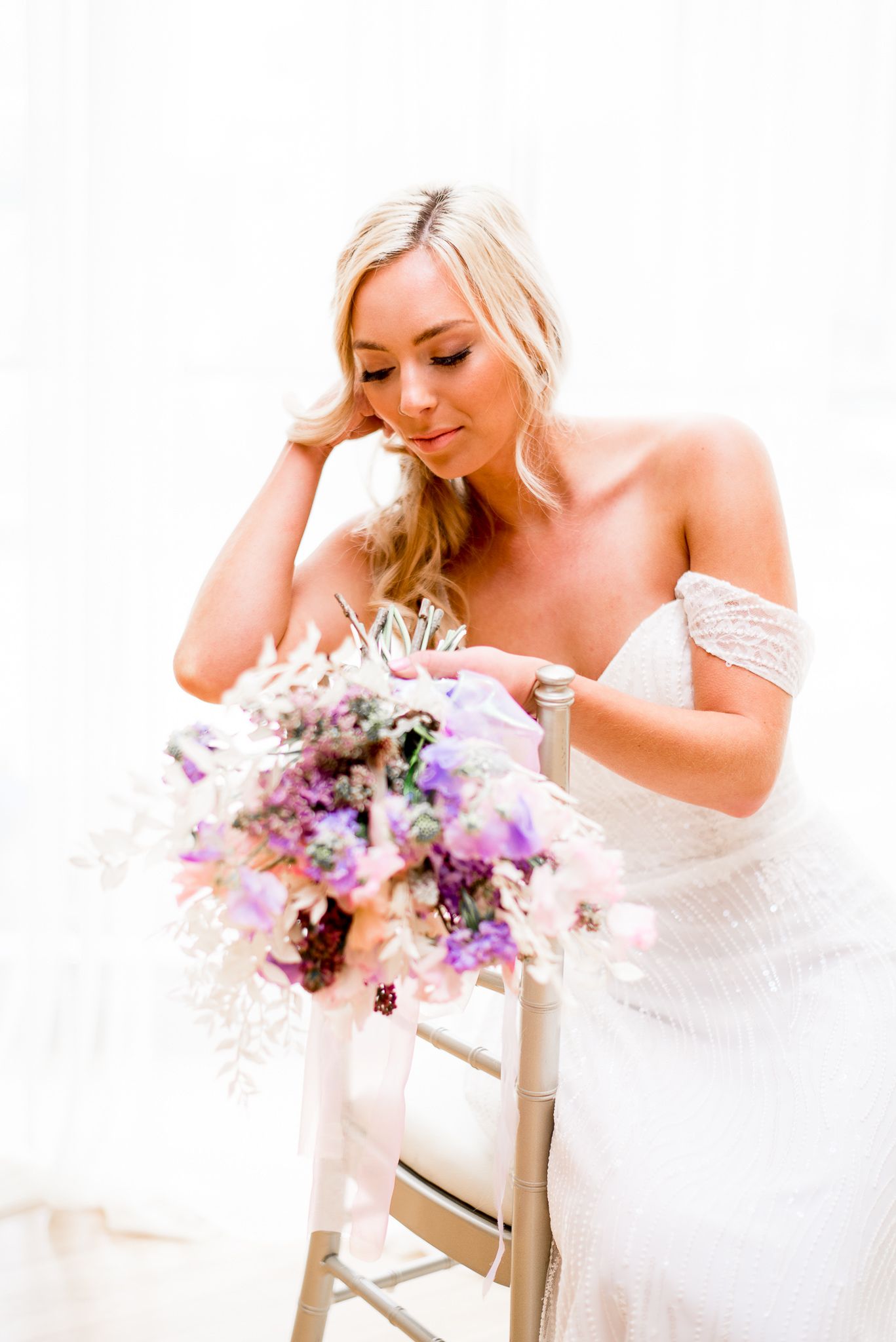 blonde bride looking at her pink and purple wedding flowers at The Center Cincinnati