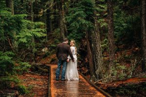 bride and groom standing on boardwalk, bride looking back at photographer