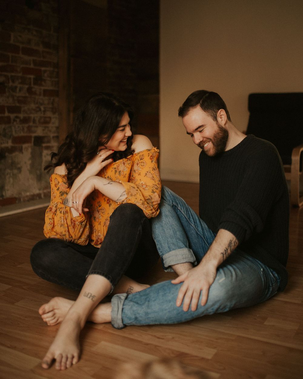 PEI wedding photographers sitting on floor and laughing together.