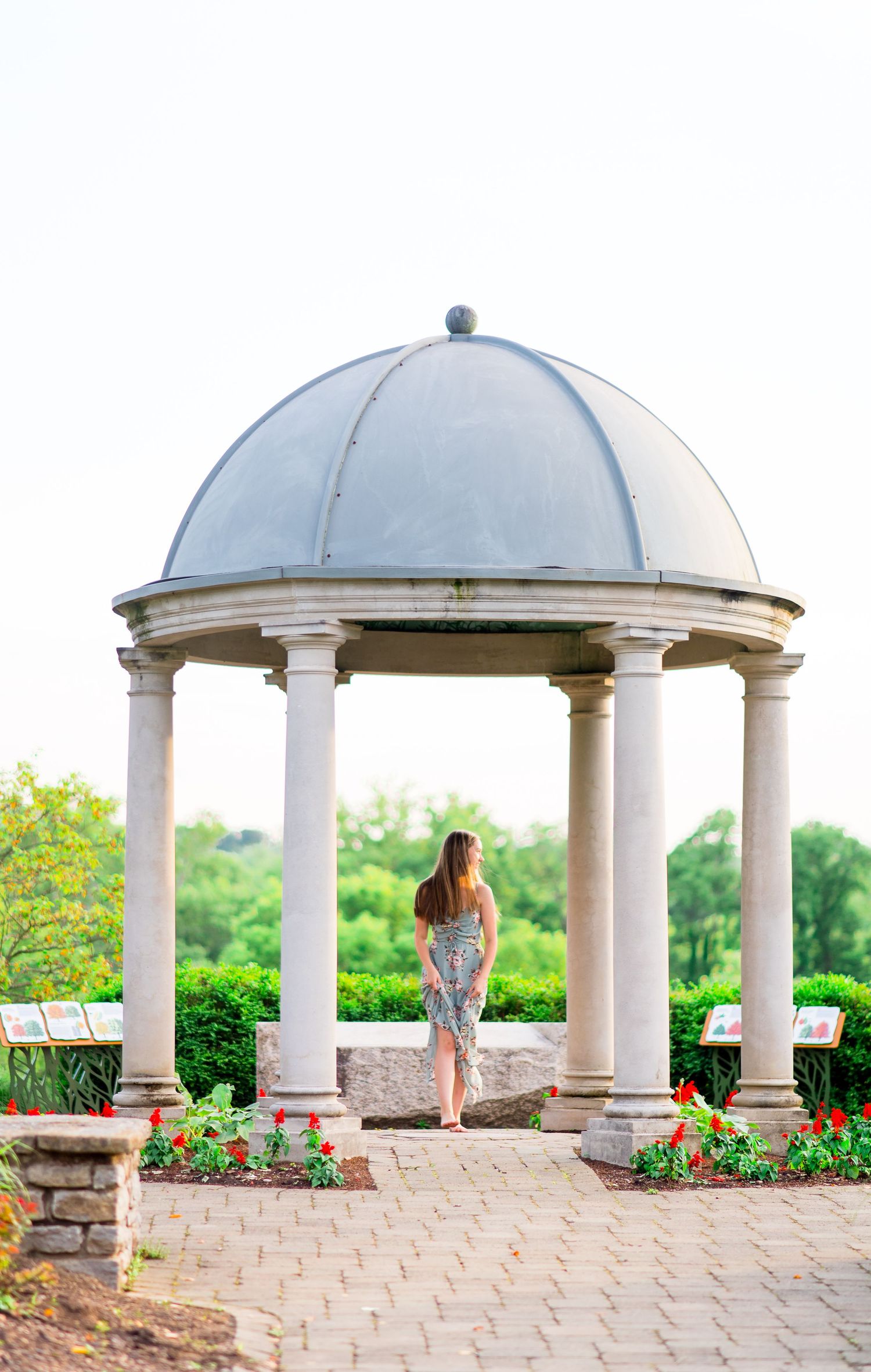 girl looks to the side under gazebo for summer senior pictures at sunset in Chicago