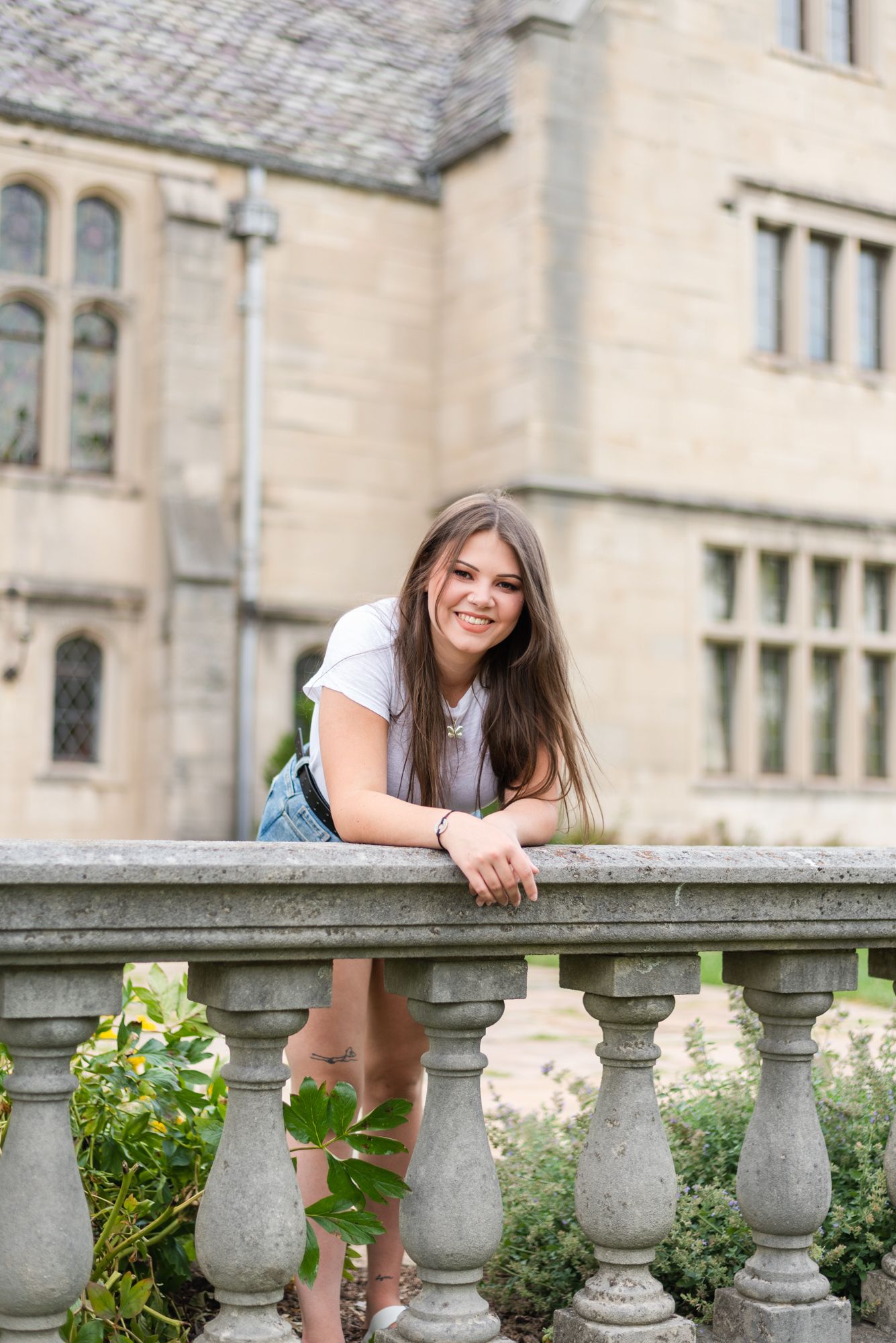 Senior smiling leaning against railing at Hartwood Acres in Pittsburgh Pennsylvania
