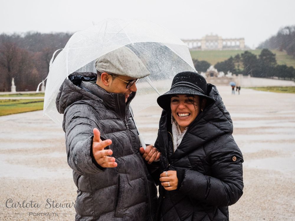 Surprise engagement photograpy of a man offering a ring to girlfriend in Schönbrunn palace gardens, Vienna, Austria