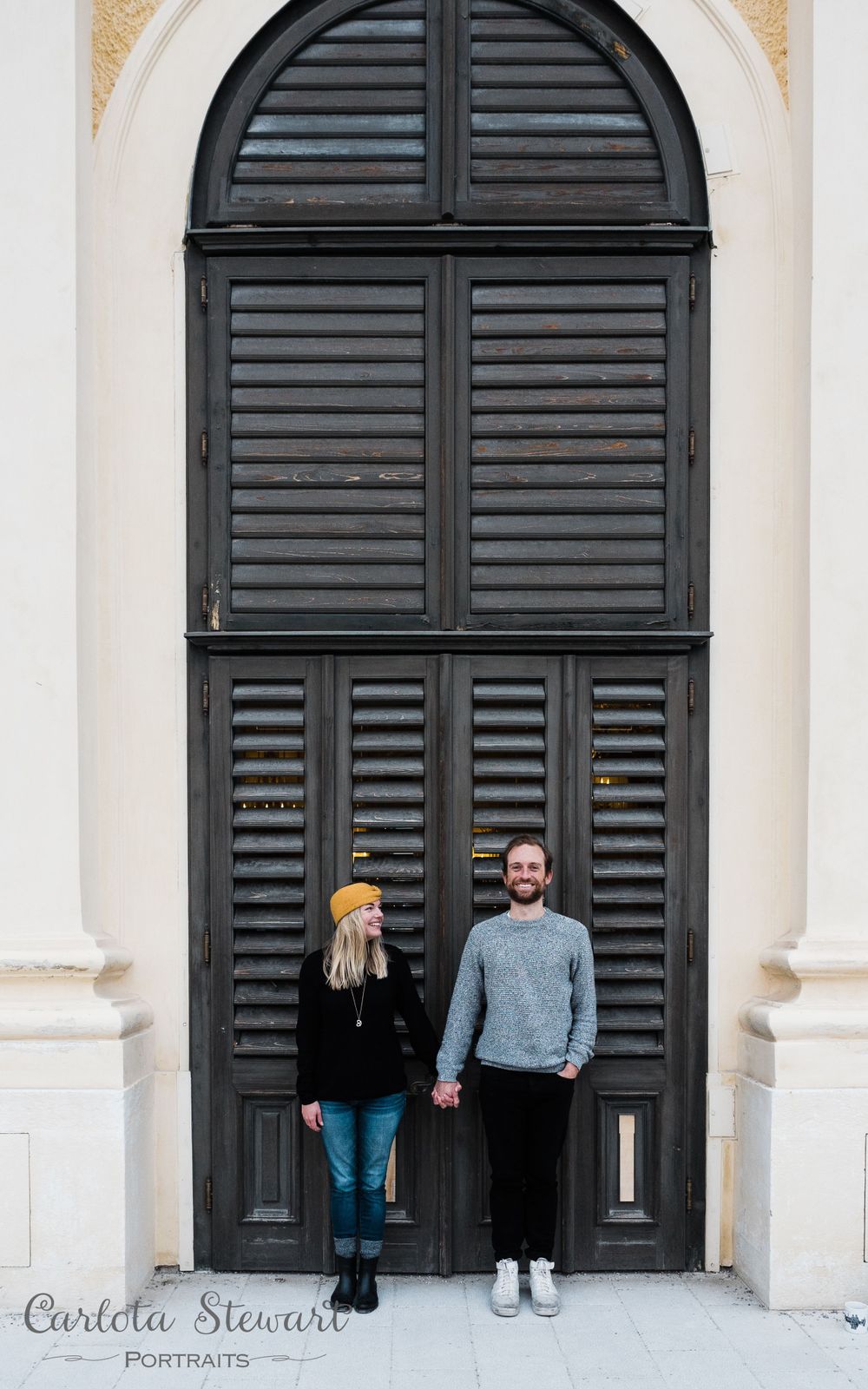 Couple photographed in front of a door during their destination photography in Vienna, Austria