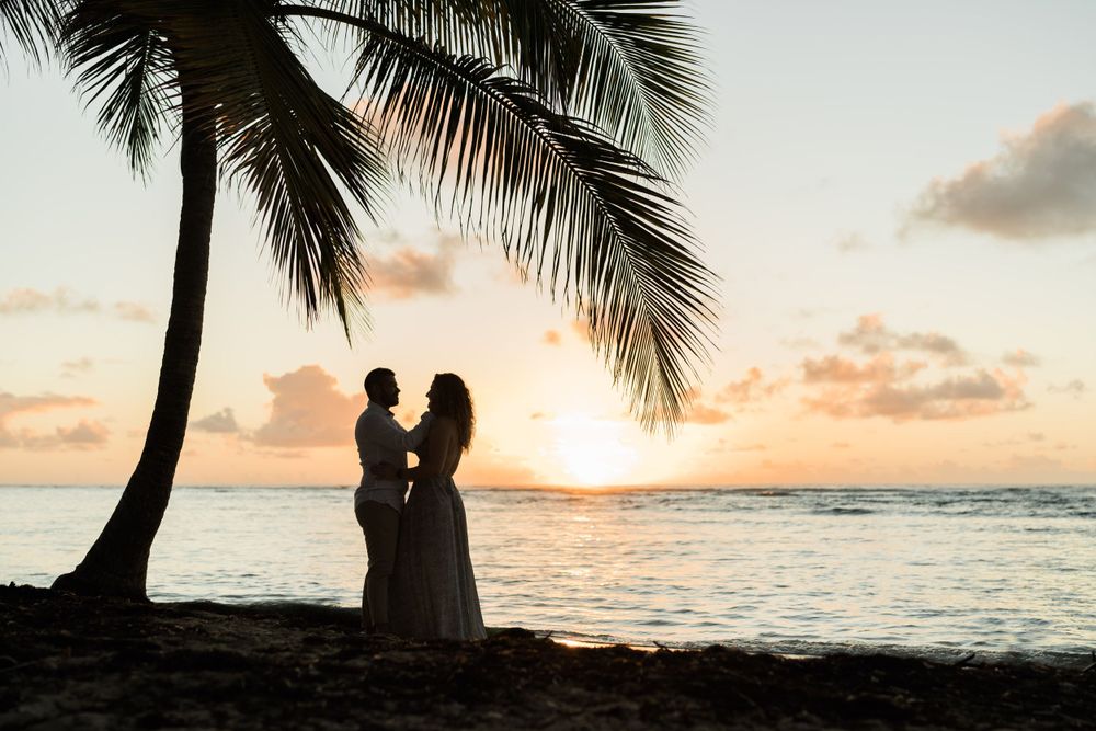 Silhouette d'un couple enlacé sur une plage au lever du soleil