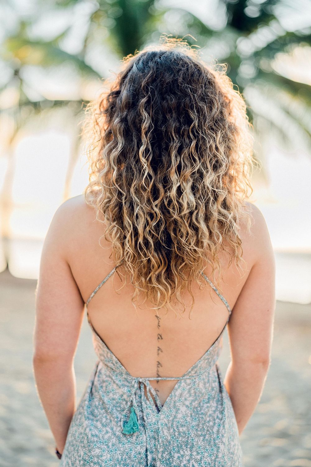 Jeune femme tatoué de dos sur une plage de Sainte-Anne