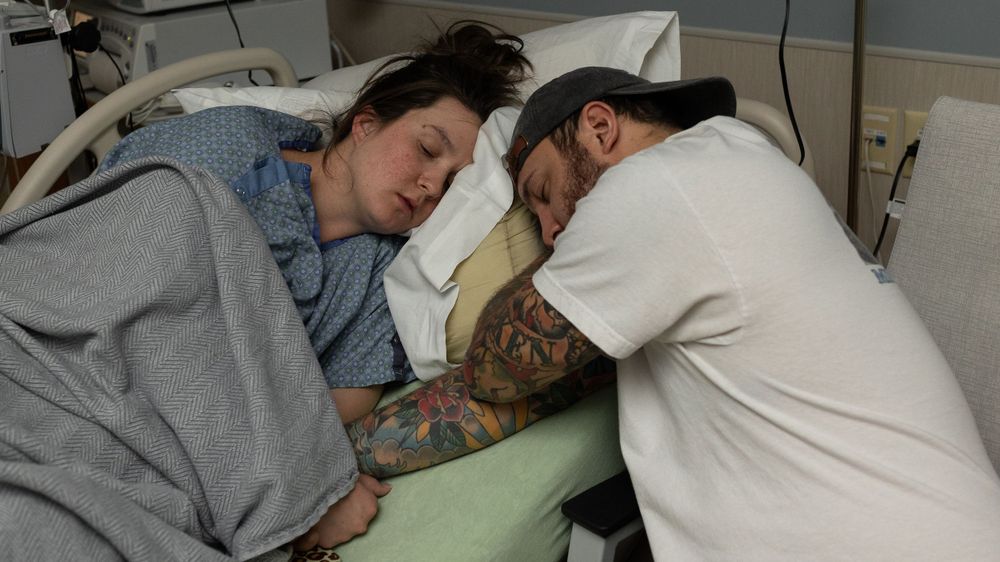 Partners resting together during their birth story in Longmont Colorado
