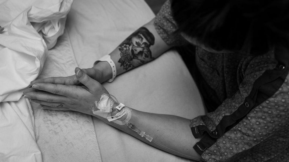 Mother clasps her hands together during a contraction at the hospital birth in Longmont Colorado