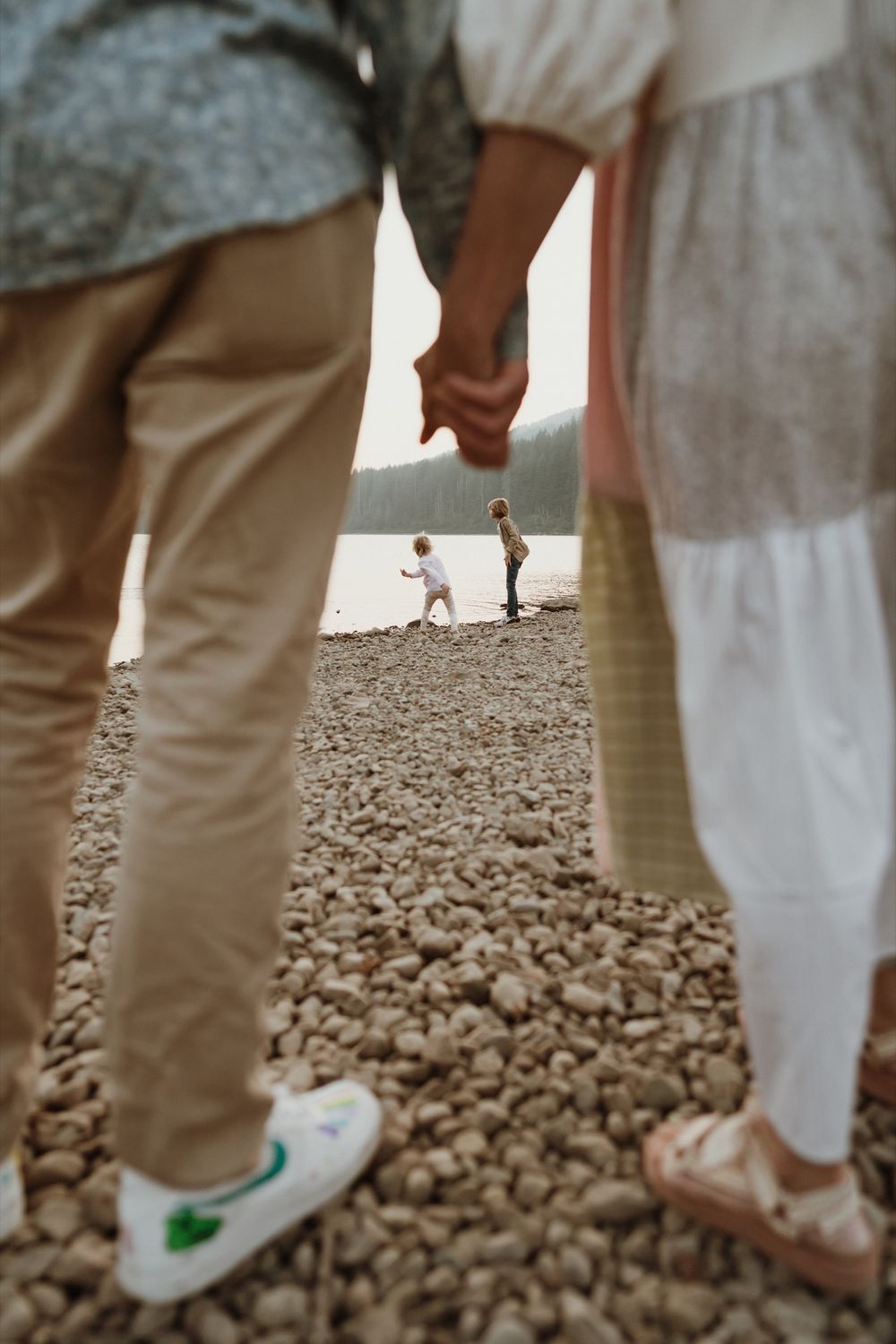 Parents holding hands with detail of little boys playing in between hands at Rattlesnake Lake