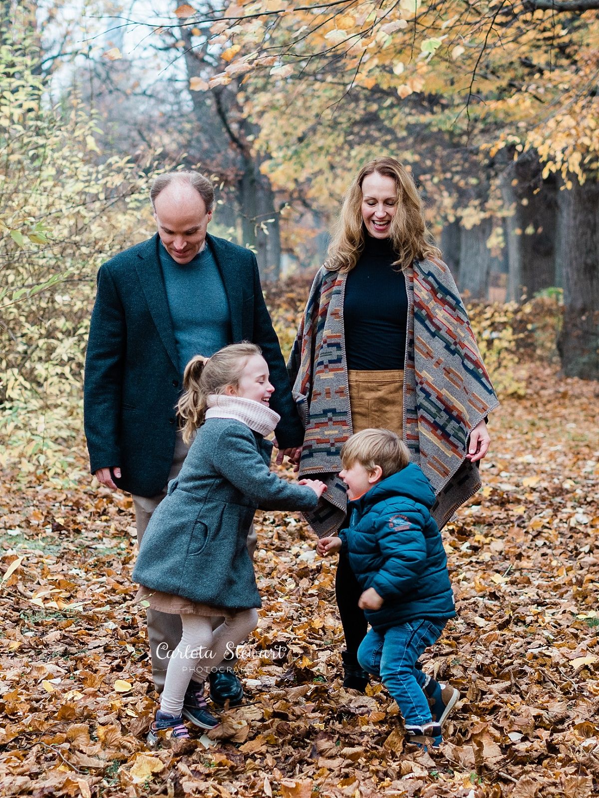 Family of four playing during fall season in a park in Vienna, Austria