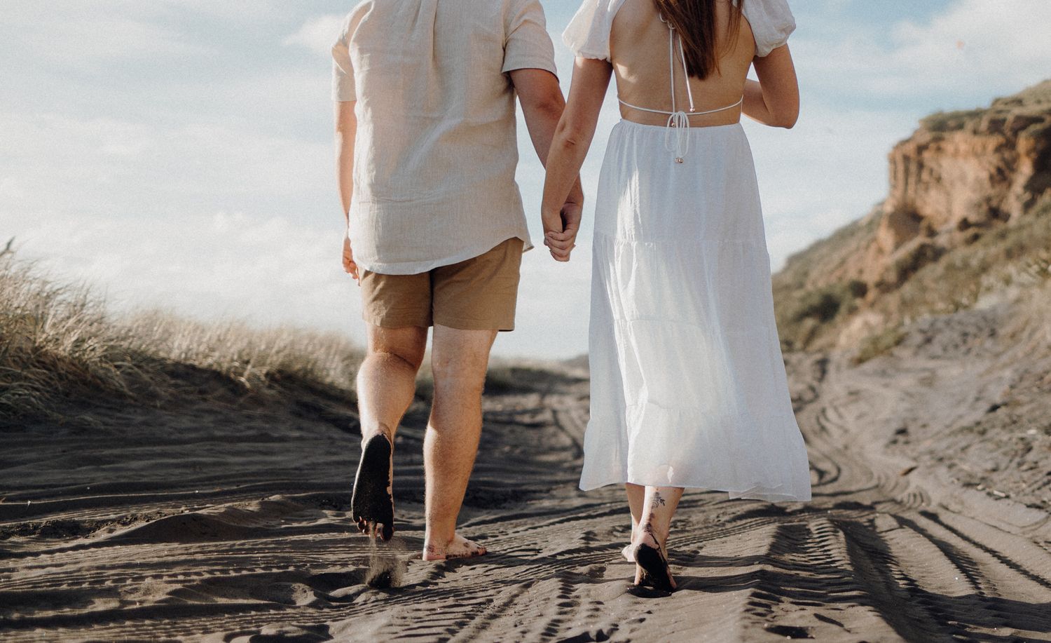 Couple holding hands in their engagement shoot in Karioitahi Beach with Apertured Media-Auckland Wedding Photographer