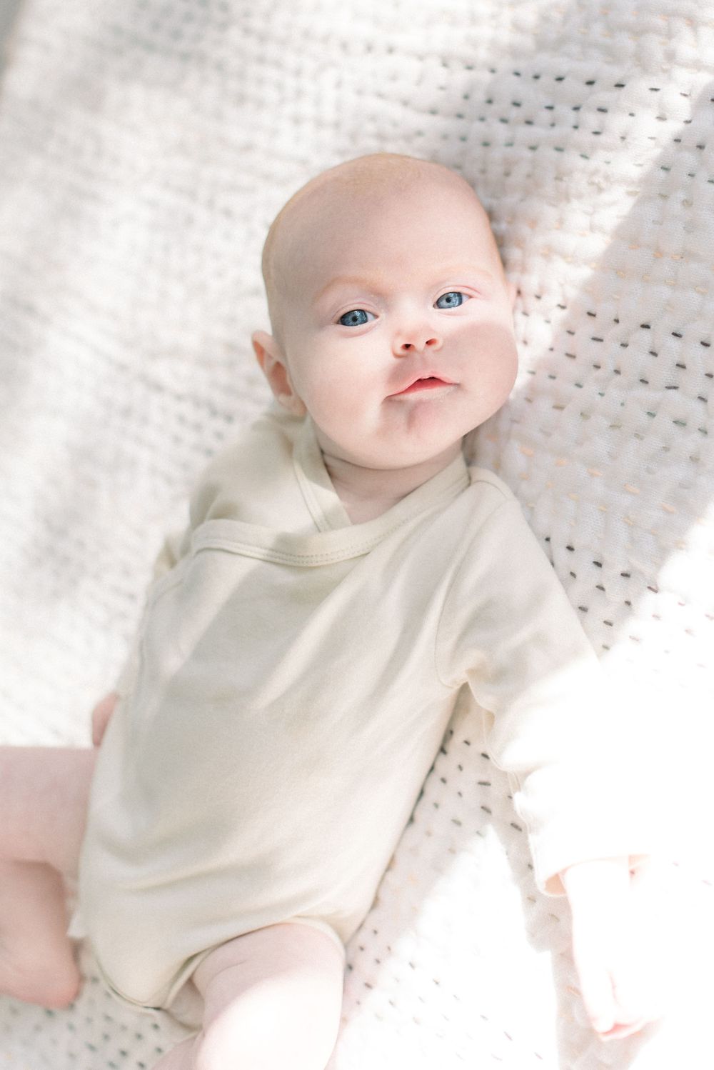 baby lying on bed captured by a washington dc newborn photographer
