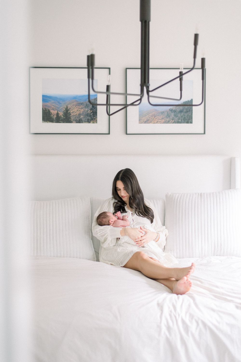 mother holding baby on bed taken by a dc newborn photographer