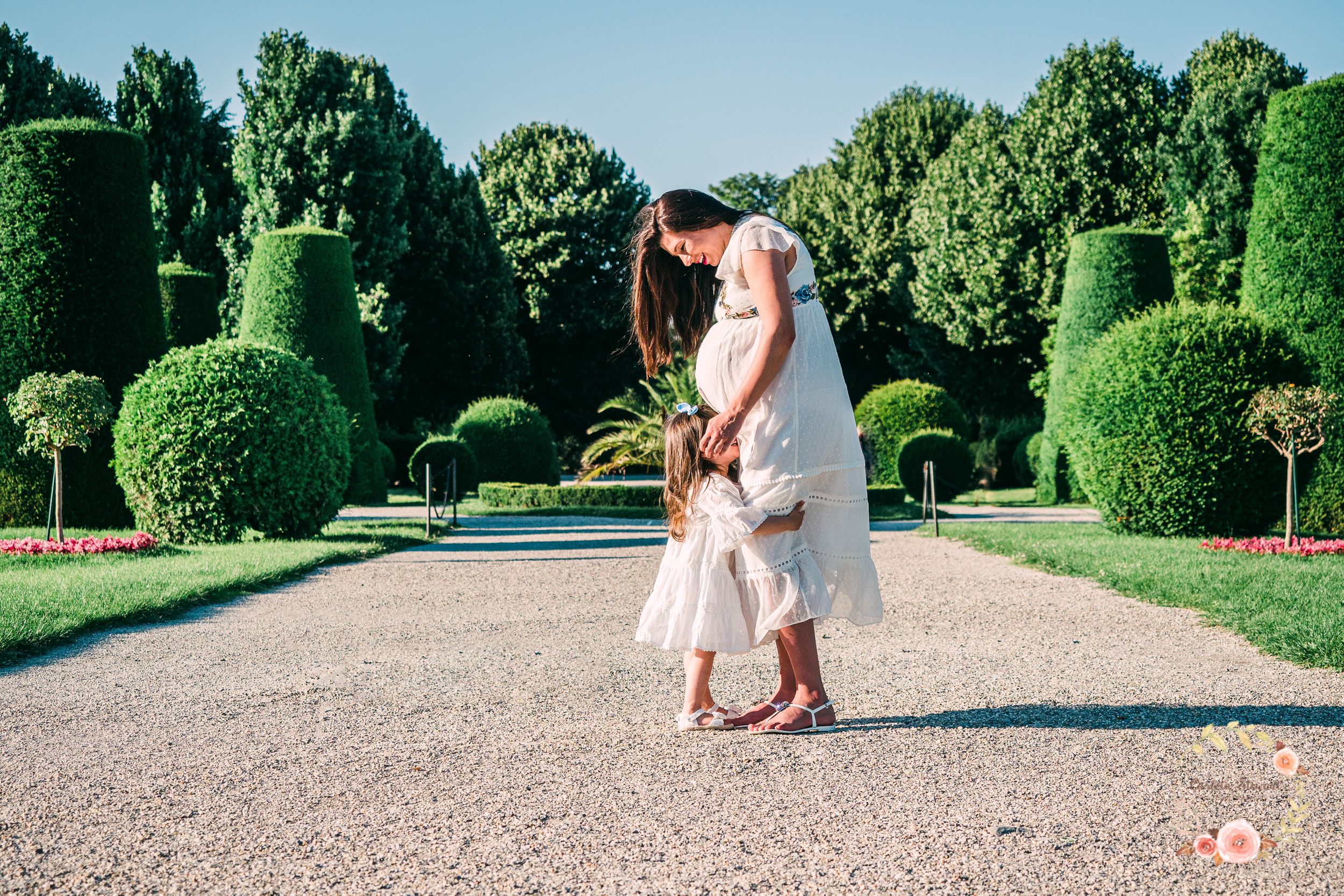 Pregnant mother comforting her child in a garden in Vienna, Austria