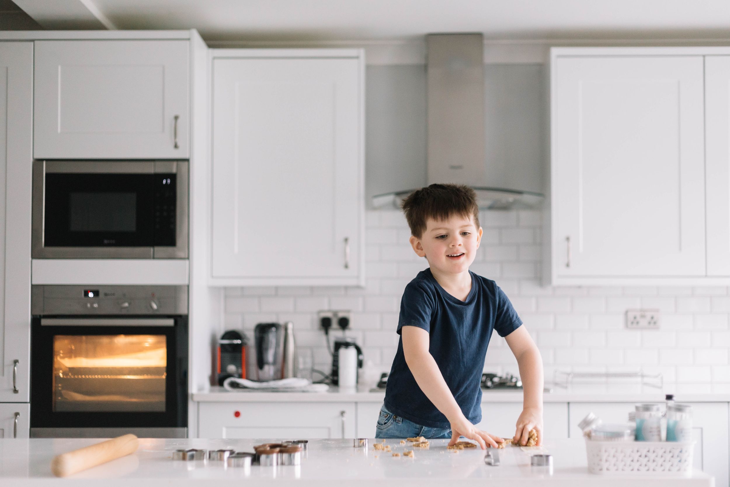 boy in navy t-shirt baking Christmas cookies