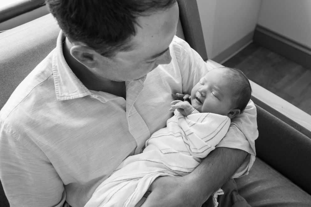 Heidi Harting captures father gazing down at his newborn in a Fresh 48 session in Plymouth, MA