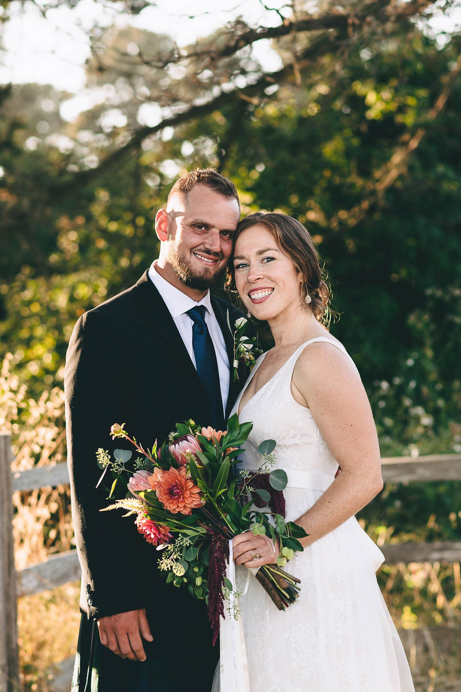Bride and groom in a golden field at sunset