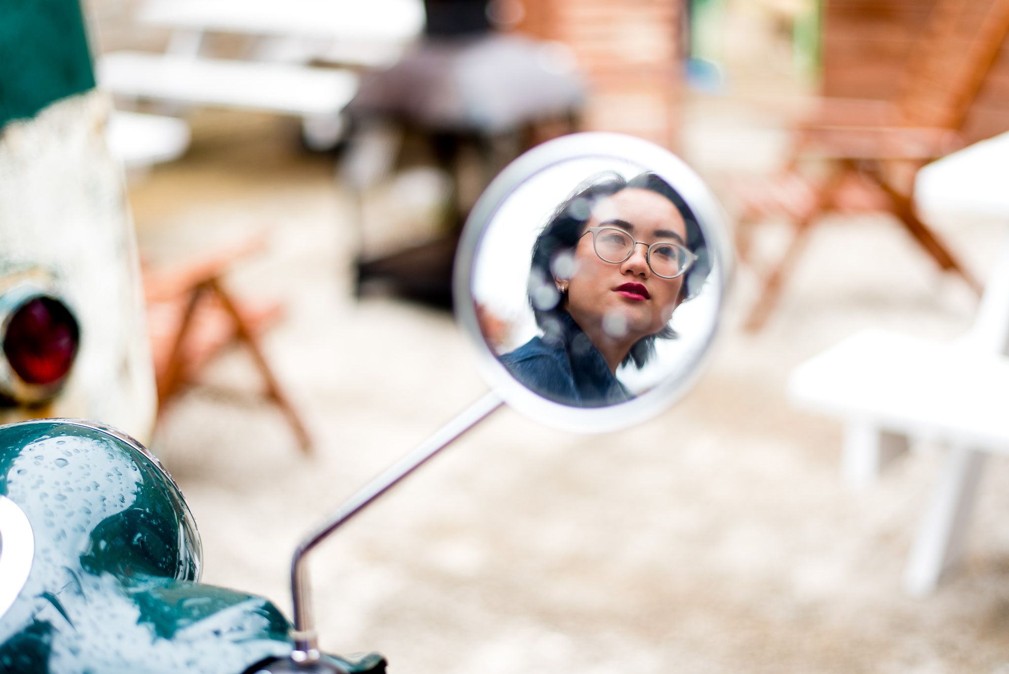 reflection of senior girl in motorcycle side mirror with rain on it for chicago senior pictures