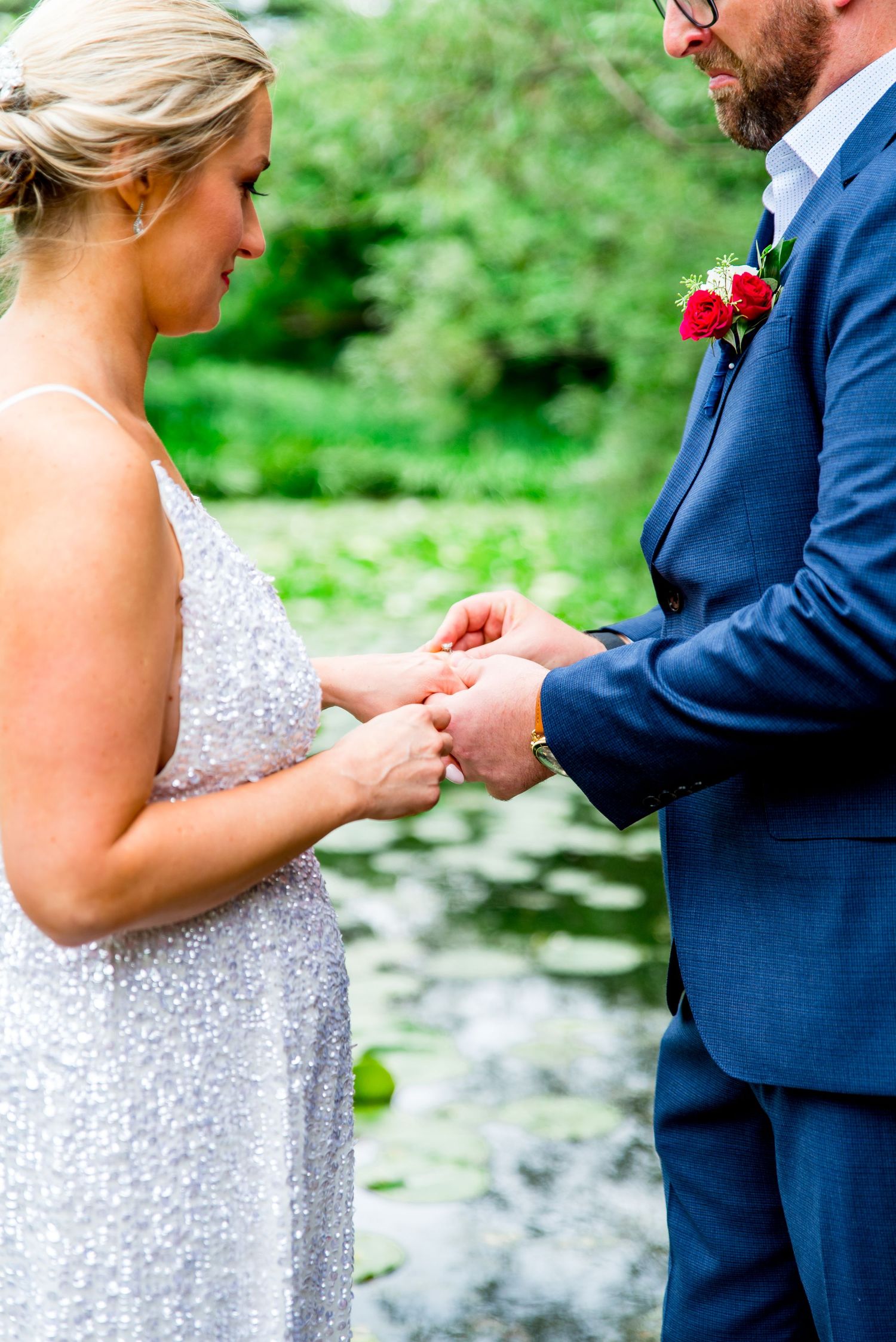 man putting ring on wife's finger at Alfred Caldwell Lily Pool summer elopement