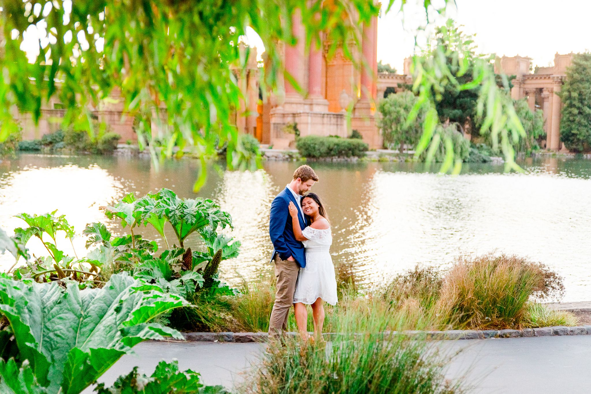 man and woman hugging and smiling in front of Palace of Fine Arts San Francisco engagement pictures