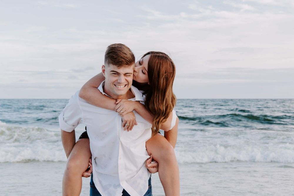 woman kissing her husband on the Cheek during their Okaloosa Island photoshoot