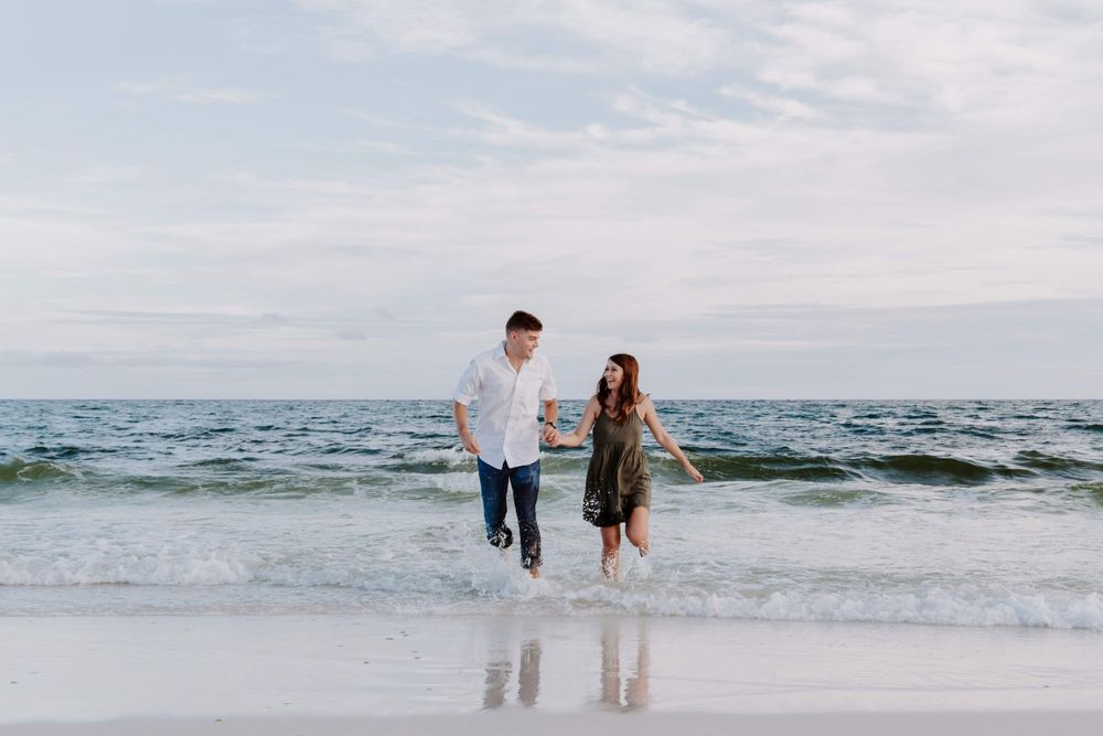 couple running away from the water on a beach in Florida