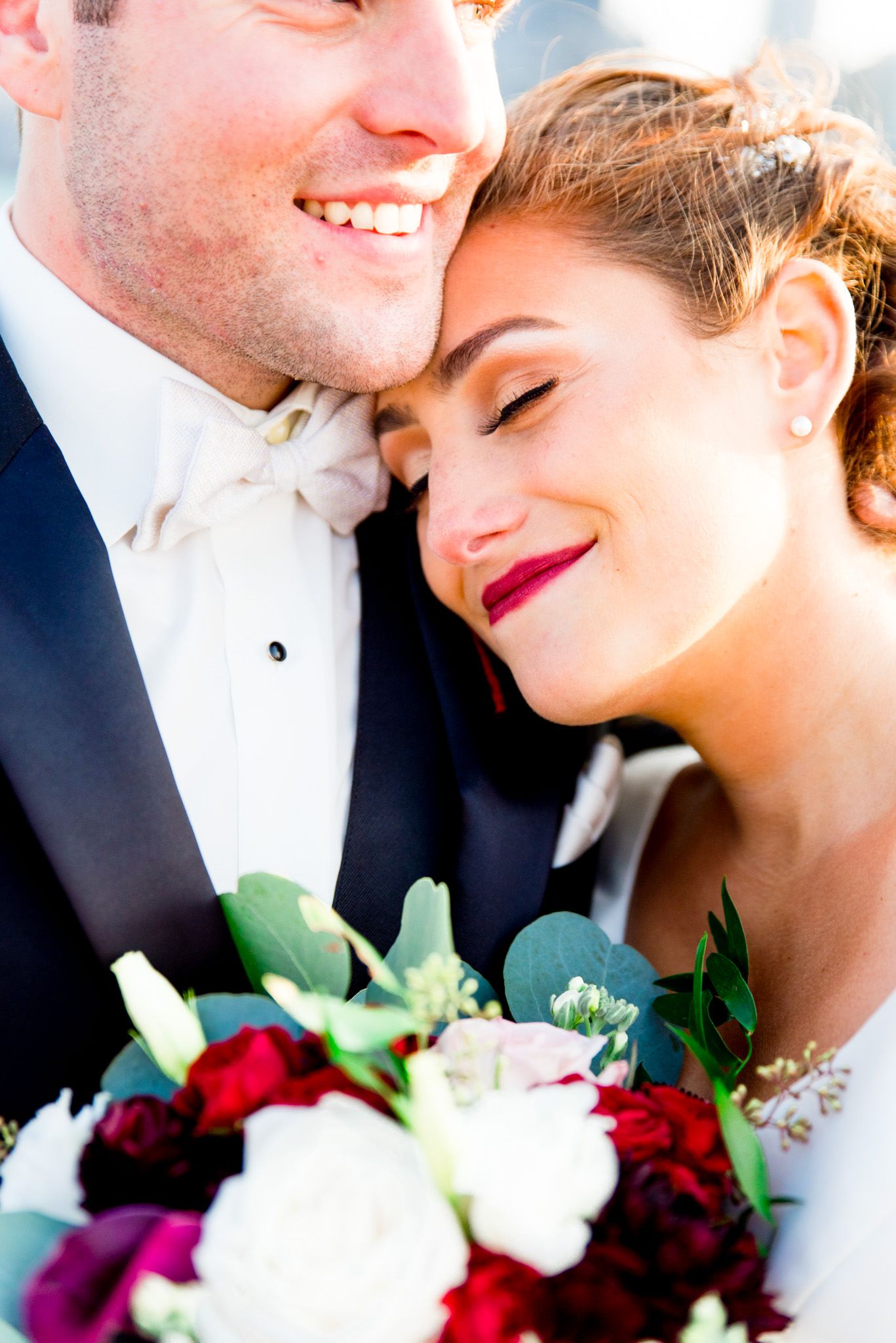 bride wearing red lipstick hugs her husband for october wedding in chicago