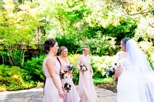 A bride having a first look with her bridesmaids in the AirBNB courtyard in Northern California