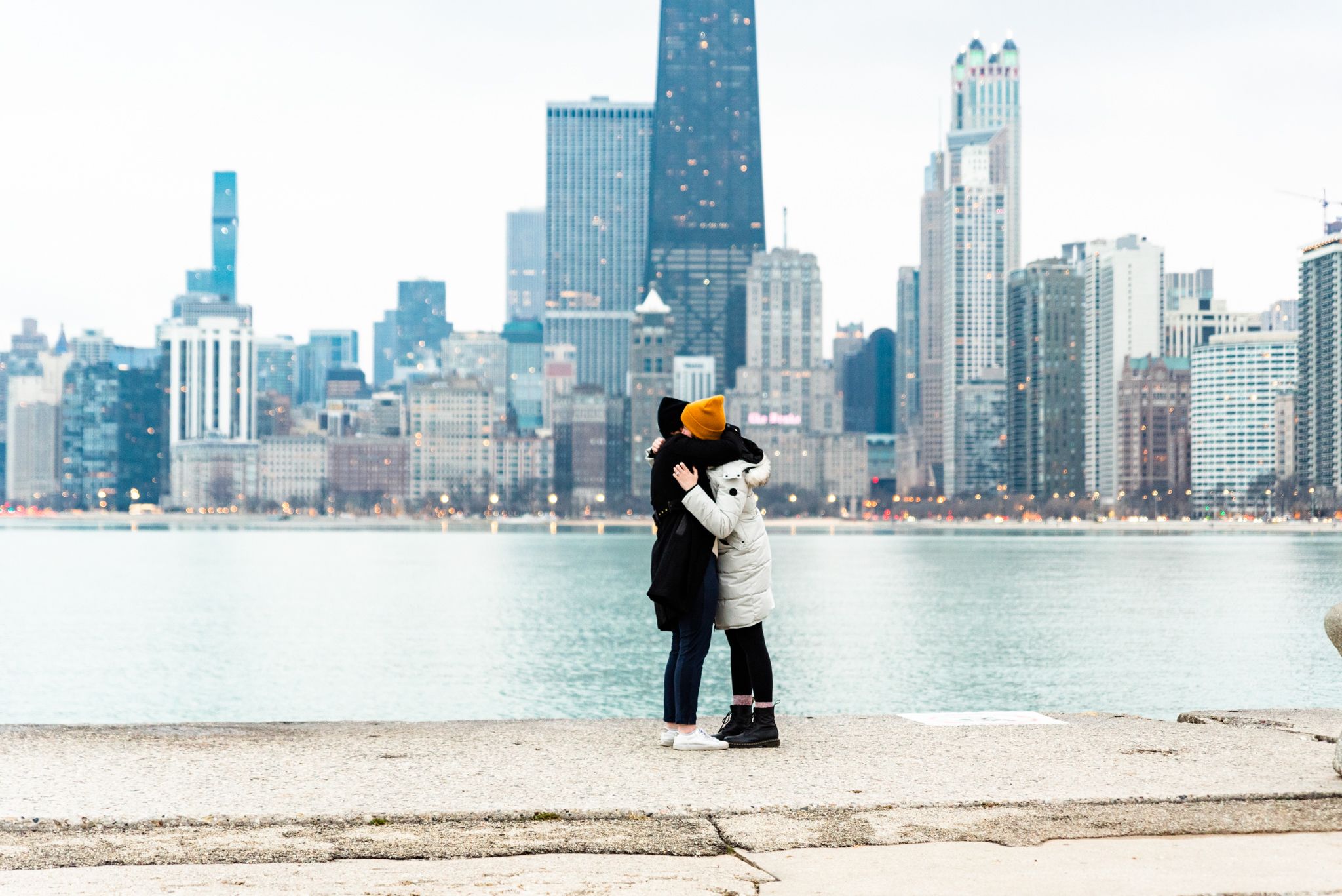 two women hugging on pier at North Avenue Beach Chicago after winter proposal