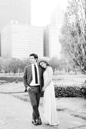 black and white photo of man looking to side and fiancee leaning on his shoulder in Chicago Grant Park for engagement