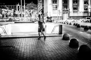 Black and white photo of woman entering underground metro in Moscow Russia