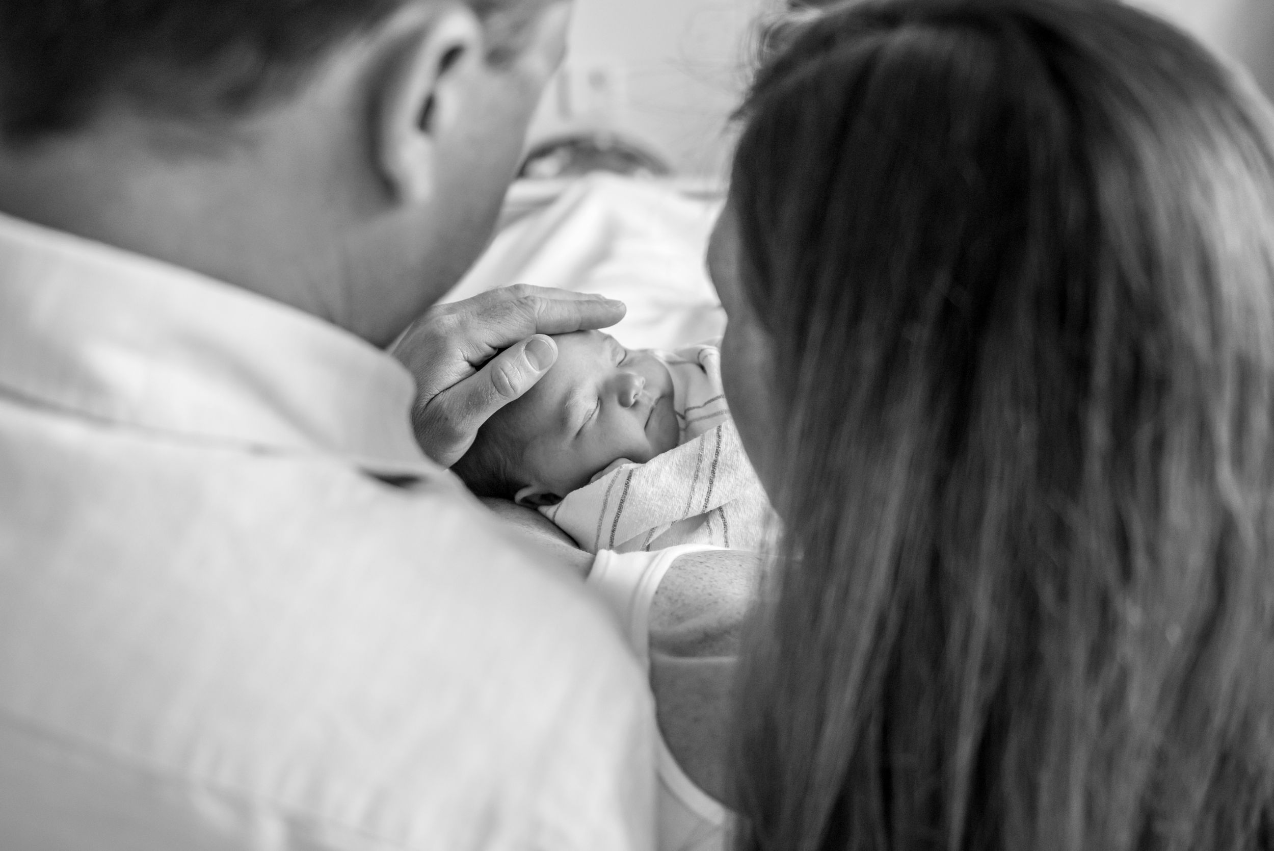 Plymouth MA newborn photographer captures parents gazing at newborn