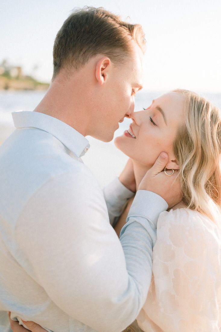 A romantic couple sharing an intimate moment on the beach during sunset.