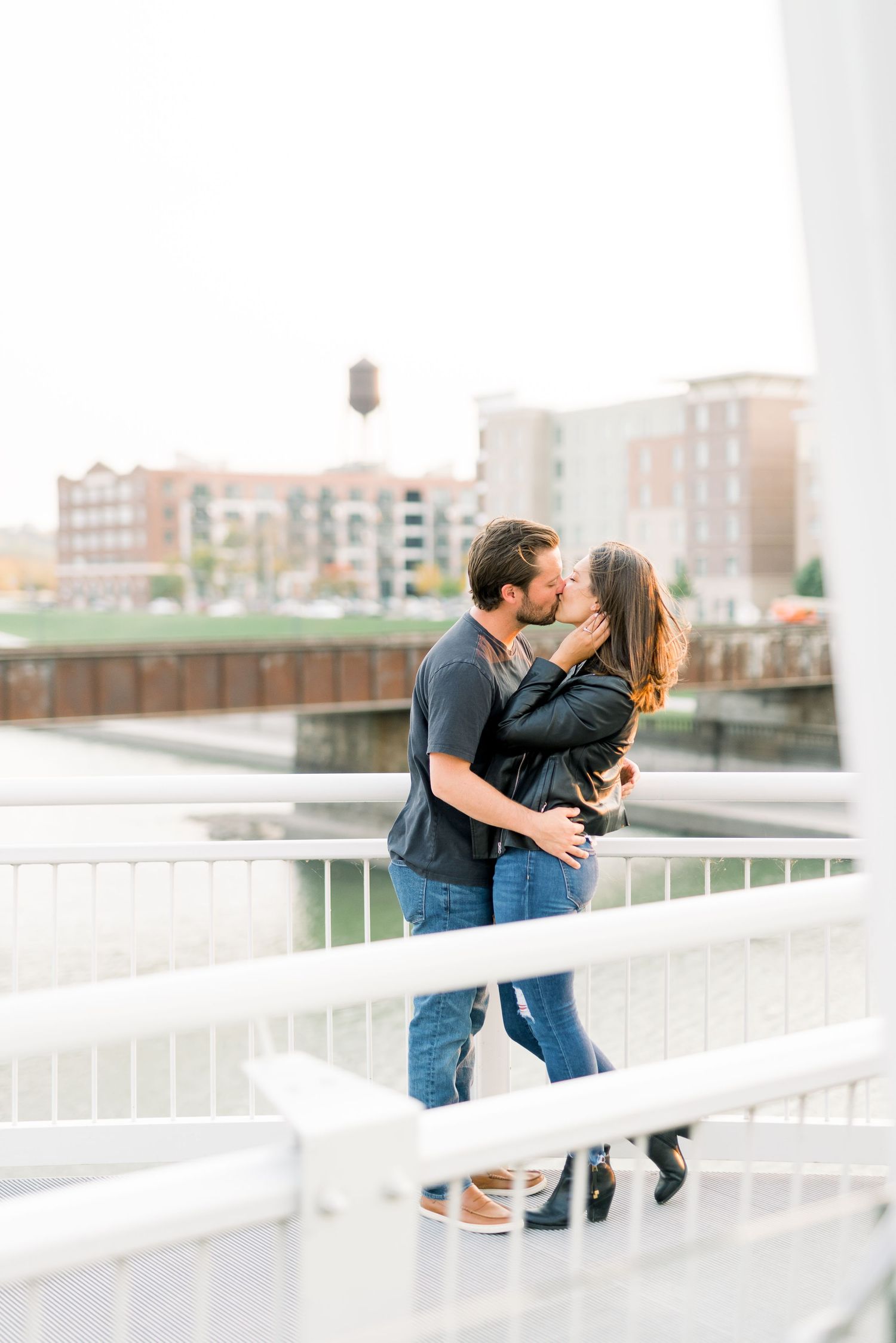 Des Moines Engagement photos on red bridge in downtown Des Moines, Iowa with light and airy photographer Nicole Laing