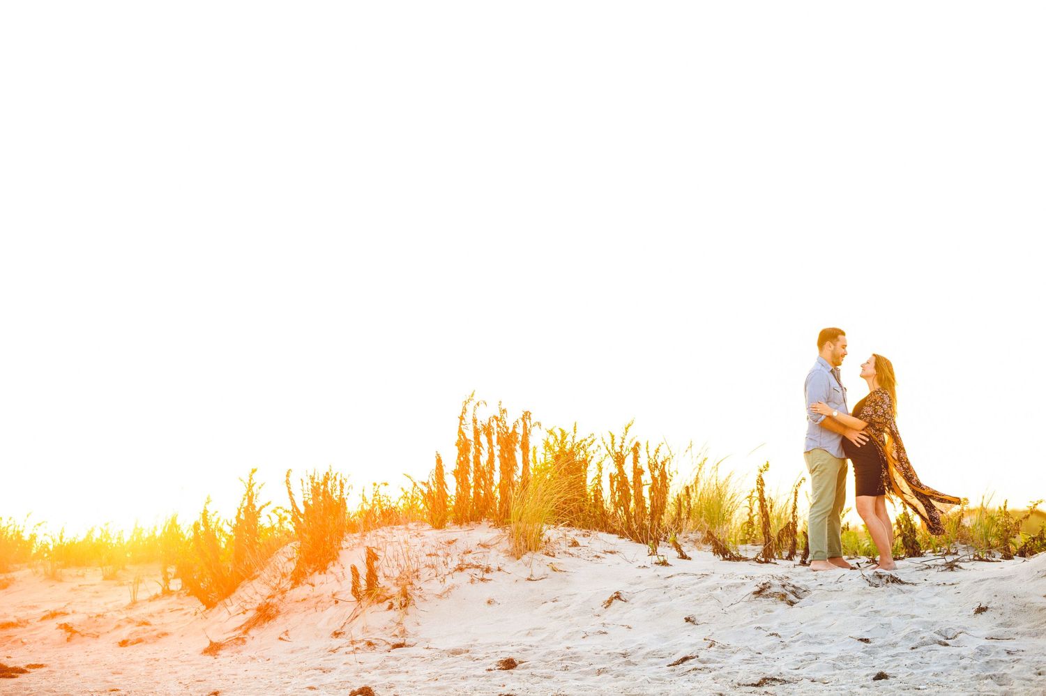 maternity couple on barnegat light beach during sunset