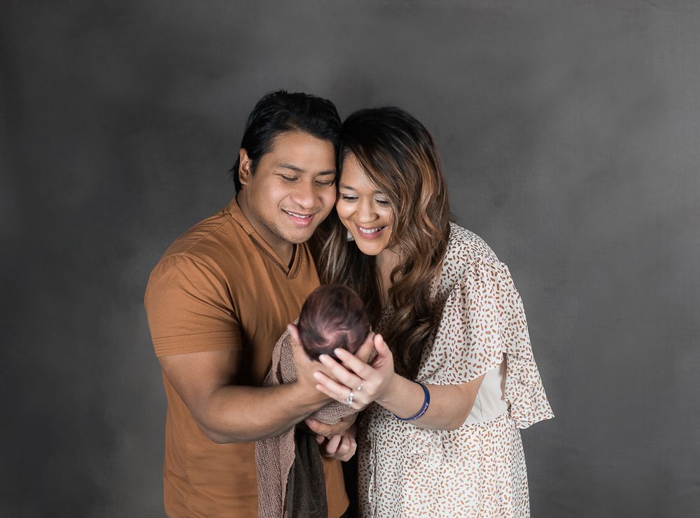 Studio Family Portrait of Young Parents Holding Their Newborn Son, Taken by Morgantown Photographer Laura Priestley