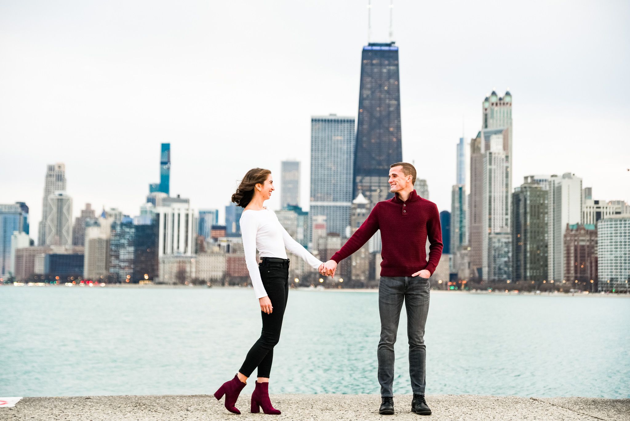 young engaged couple holding hands at North Avenue Beach engagement pictures in Chicago