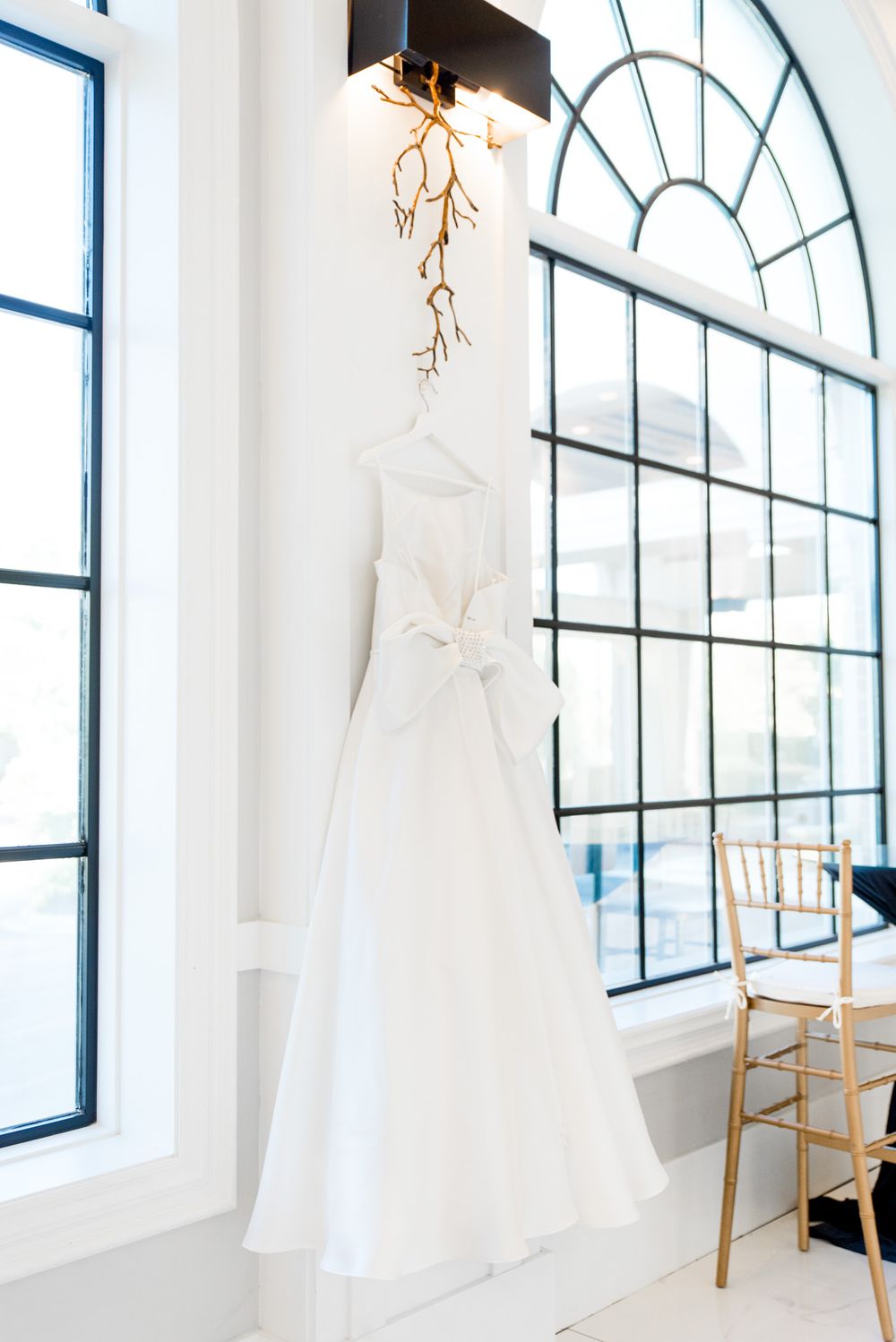 bright white wedding dress hanging between windows in chicago