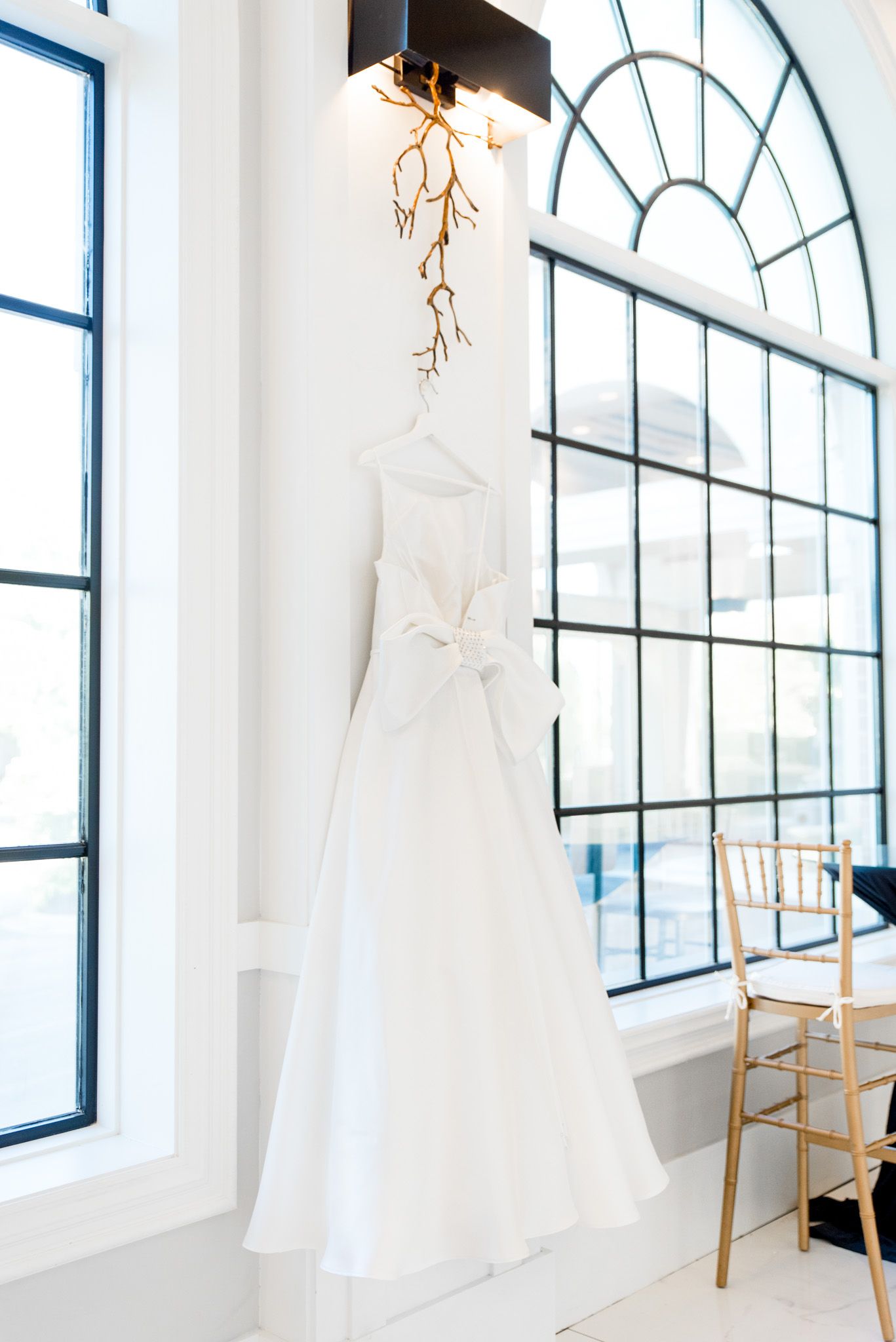 bright white wedding dress hanging between windows in chicago