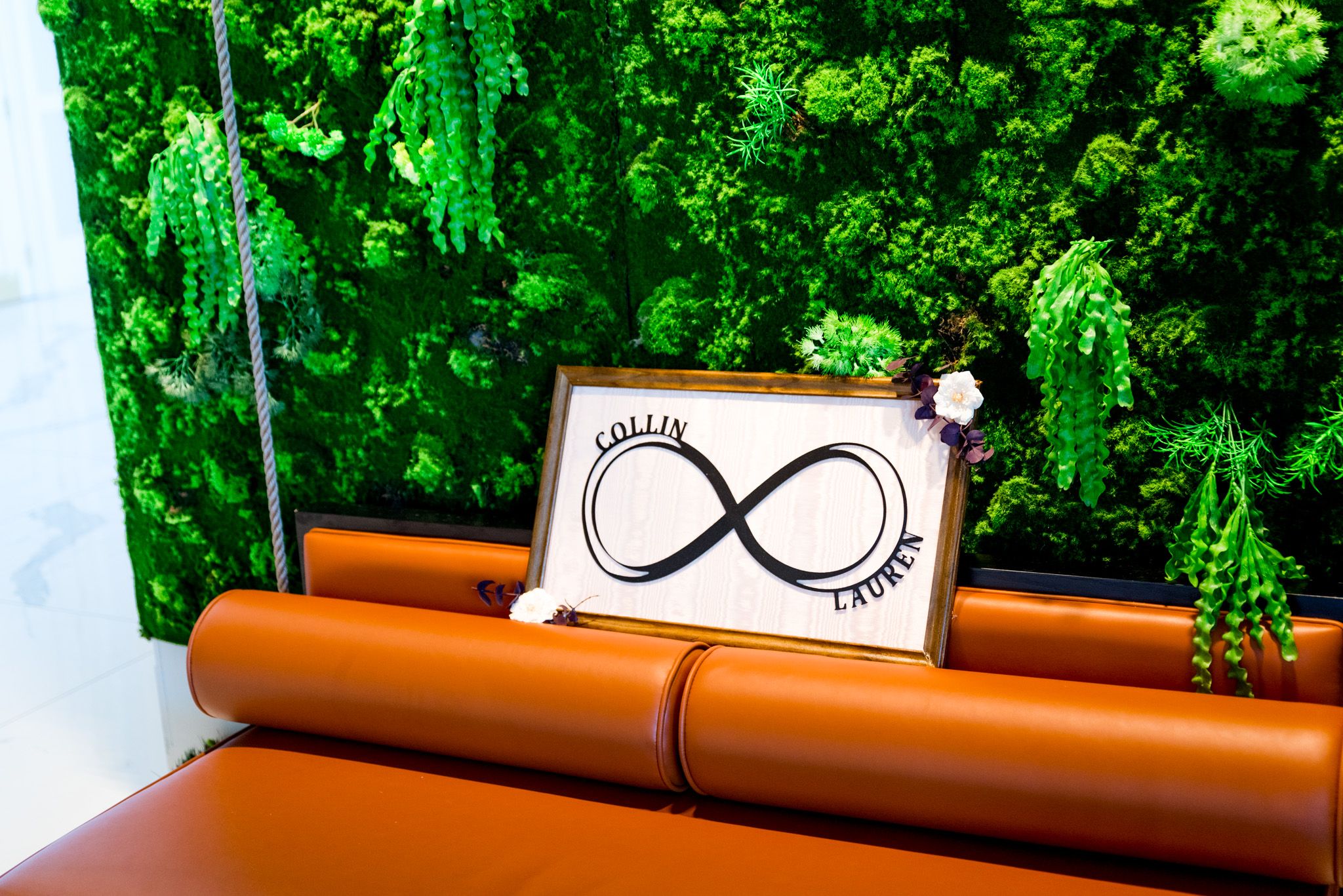 chicago wedding photographer, greenery wall with infinity love symbol above a modern orange couch