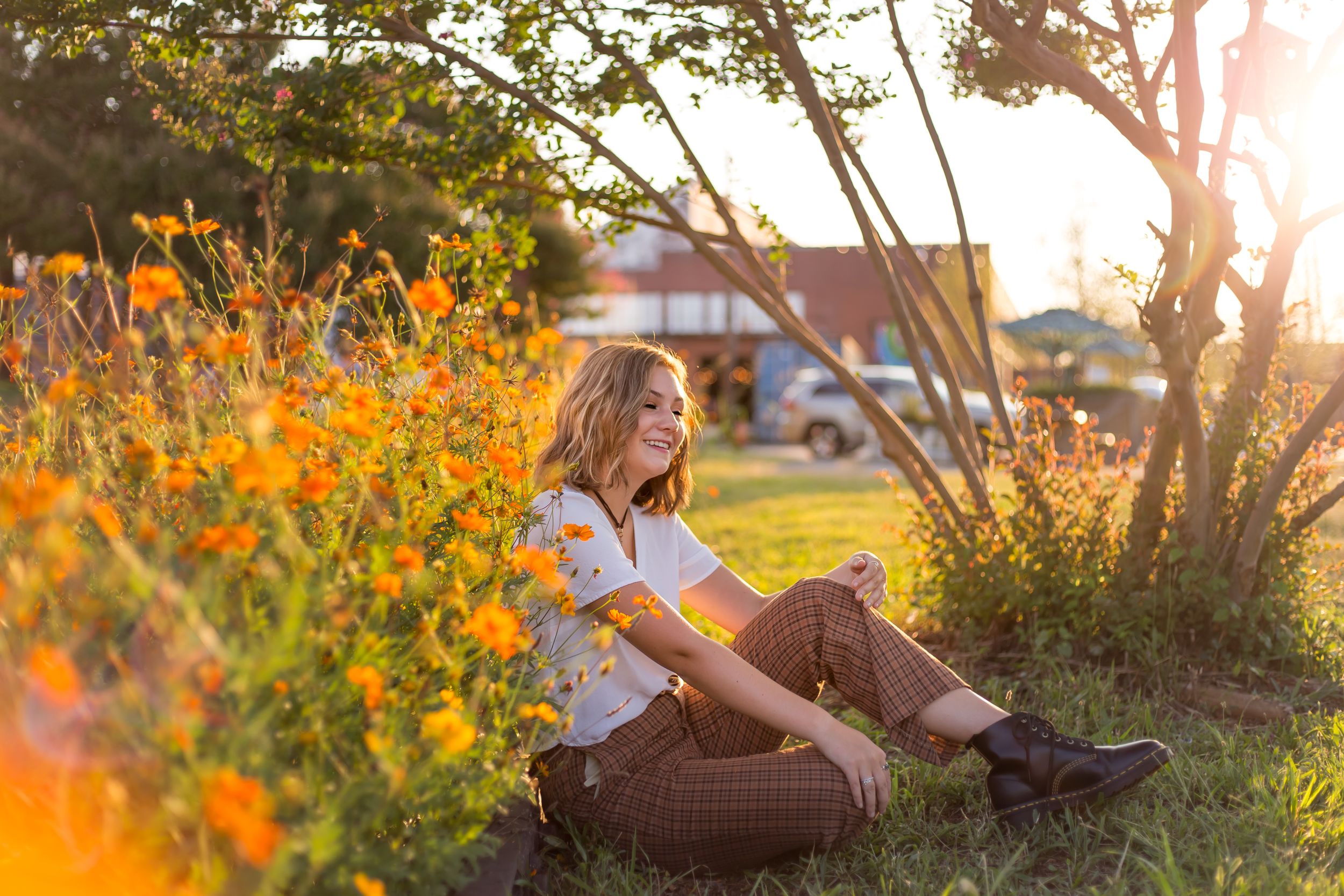 Young woman laughing while sitting in wildflowers at Camp North End