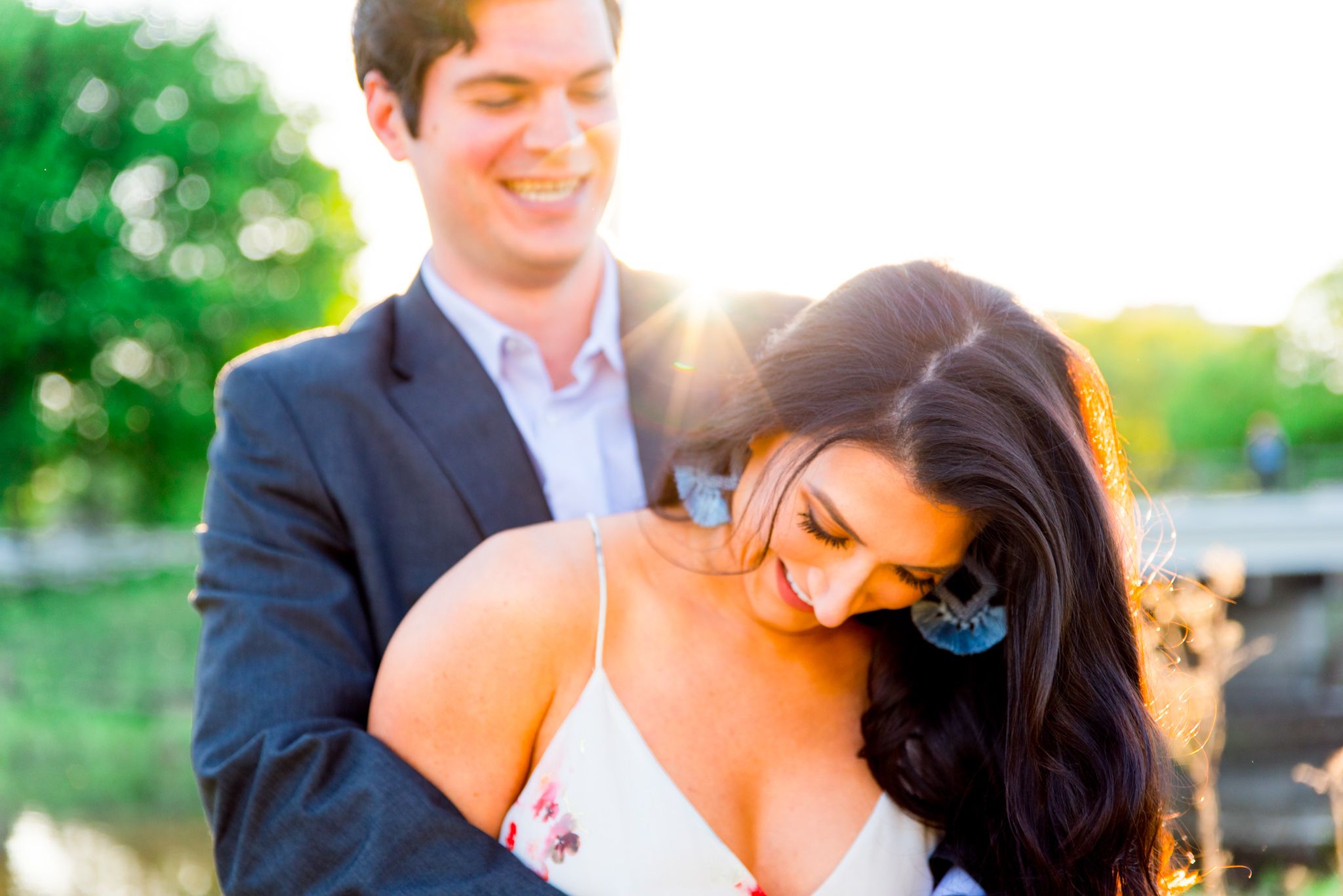 man hugging woman with blue earrings from behind making her laugh for Lincoln Park engagement pictures